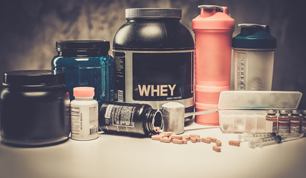 Supplements displayed on a counter including protein powder and multivitamins