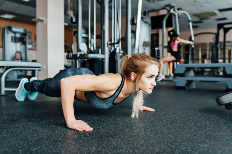 Girl Doing Pushups Concerned About Symtoms of Overtrainning and Overreaching
