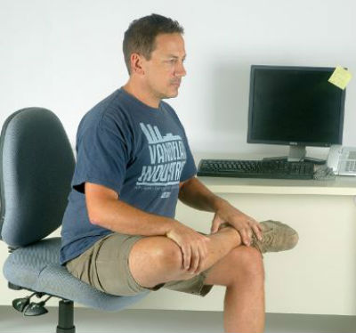 man doing seated hip stretches at work