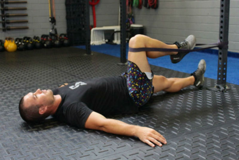 man performs a psoas hold using a band as one of his favorite sports hernia treatment exercises