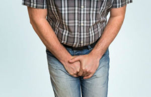 man with inguinal ligament pain symptoms holds his groin