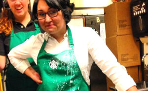 Starbucks barista stands with hands at hips after spilling keto low carb coffee drink on herself