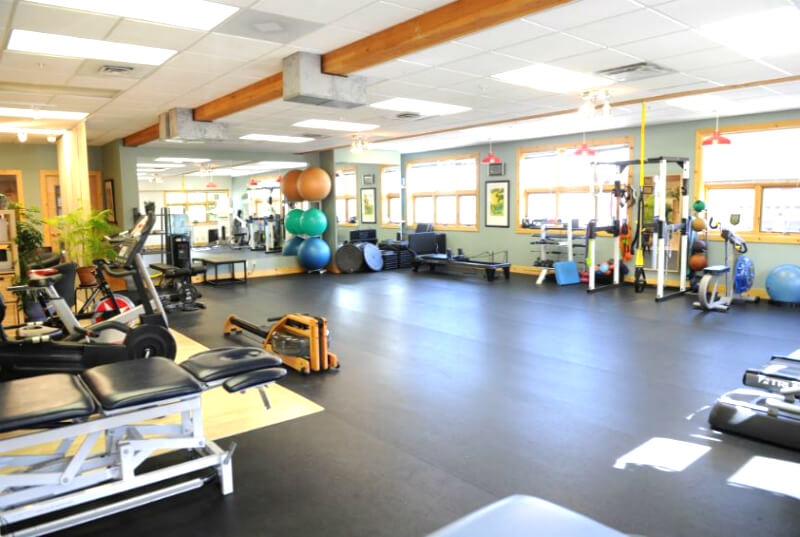 Clinic physical therapy equipment shown in brightly-colored gym