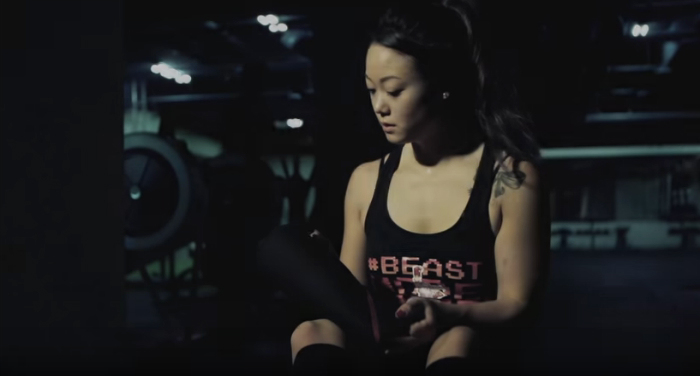 Woman Powerlifter puts on SBD knee sleeves before squatting