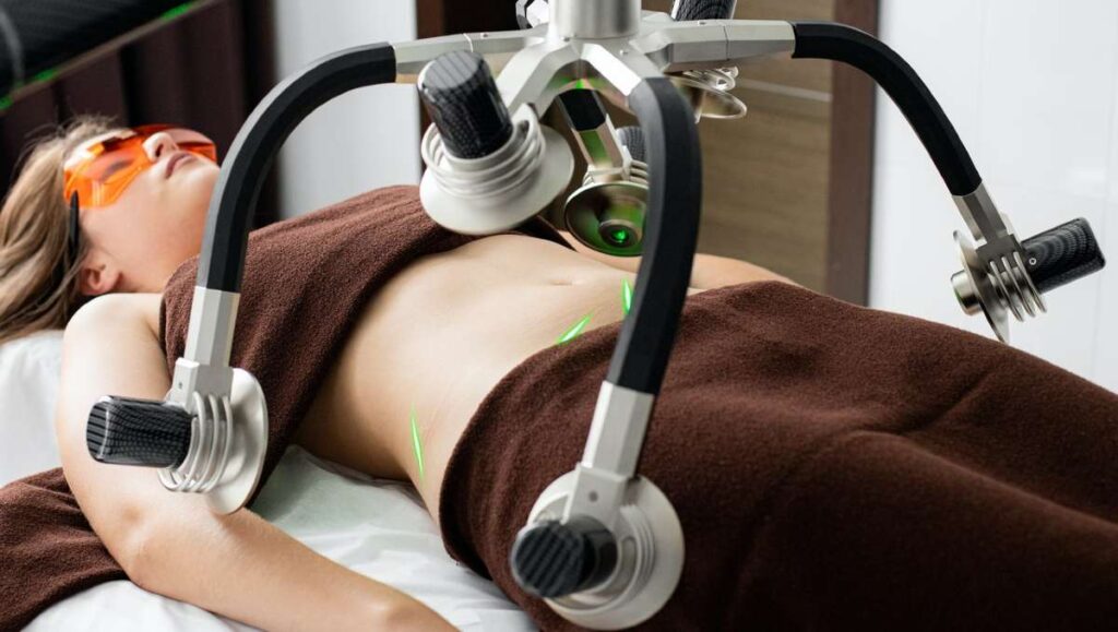 A woman lying on a table with a heat treatment device on her belly. 