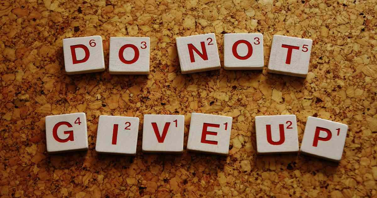 Arranged scrabble tiles spelling out "do not give up".