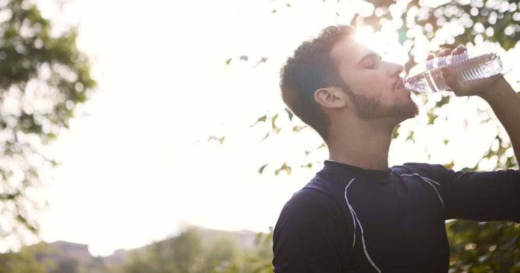 A man drinking water after exercising. 