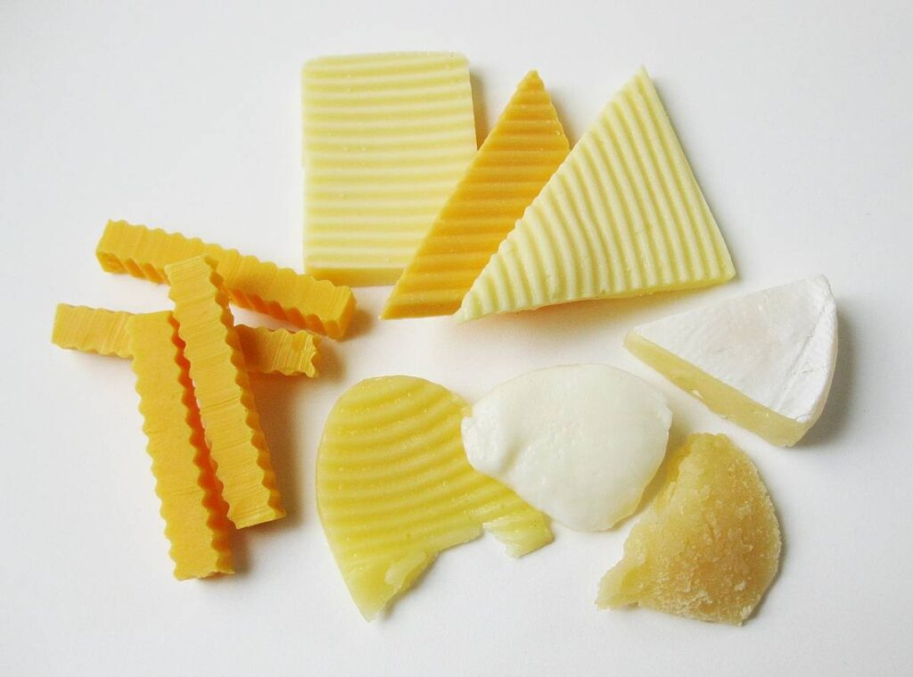 Blocks of cheddar cheese cut into different shapes.