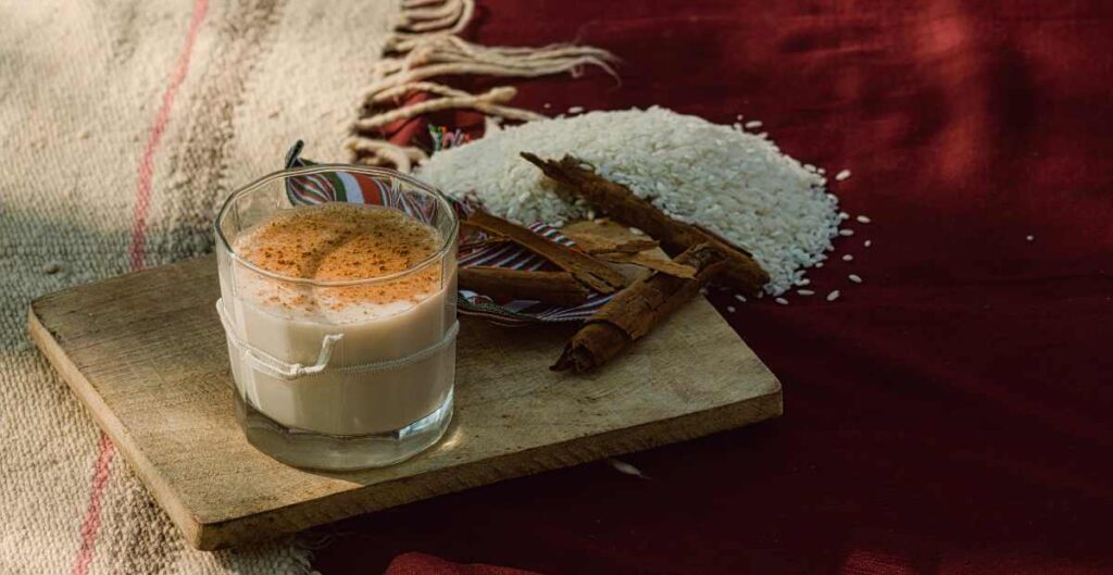 A glass of white and milky horchata with cinnamon on the top. 