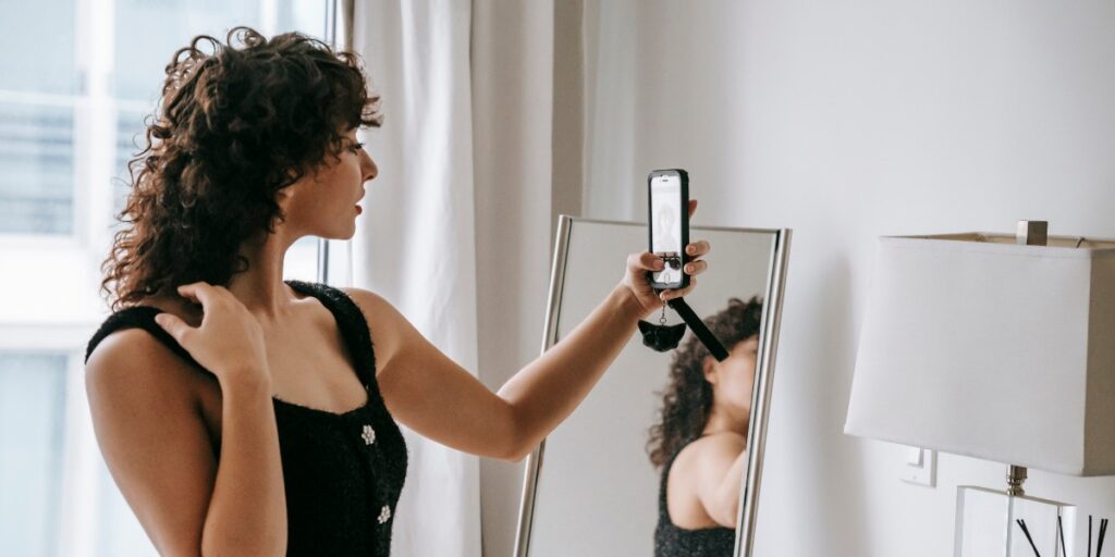 A woman taking a picture in the mirror to track her weight loss progress. 