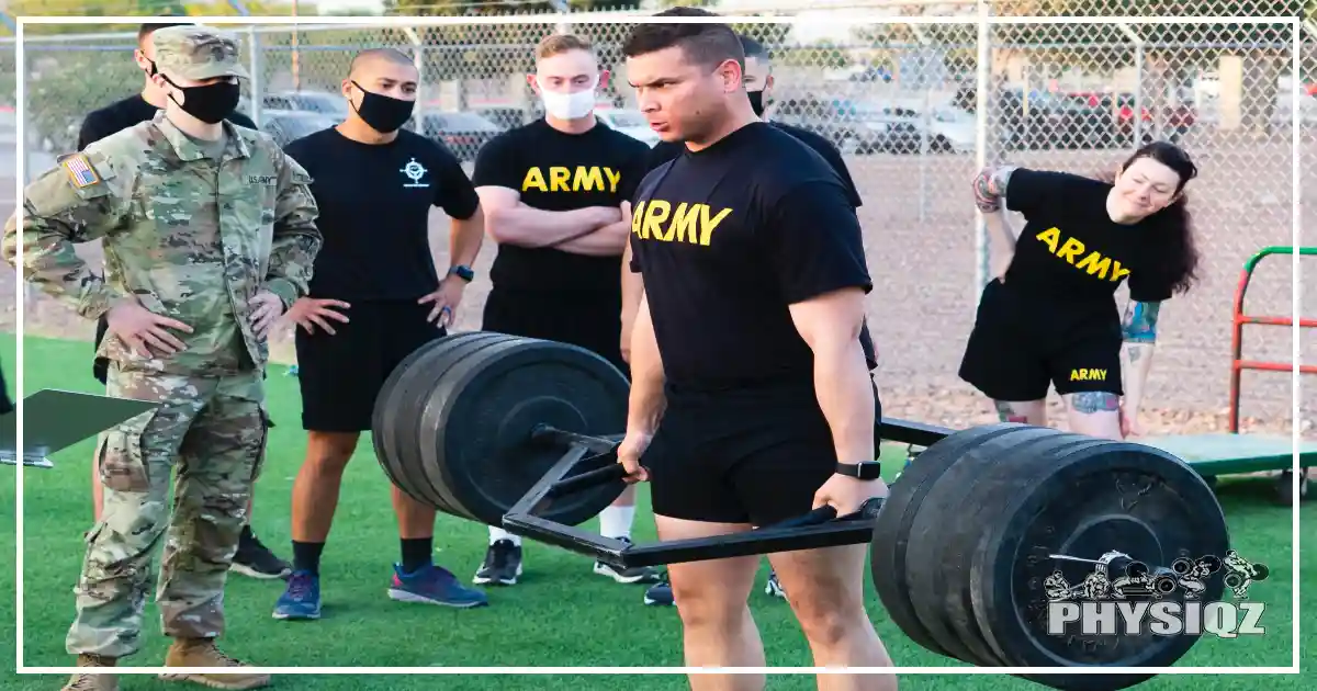 A guy in an army shirt is at the top of a trap bar deadlift while five other squad members stand behind him for support. 