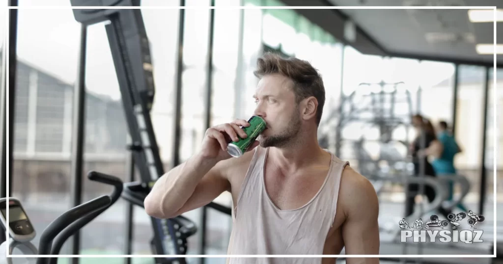 A man drinking an energy drink such as Bang, Monster, or Redbull while he's training at the gym. 