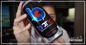Woman holds a black can of energy drink with blue Bing logo while looking at the nutritional information label on the back to decide is bang good for weight loss to add to her diet plan.