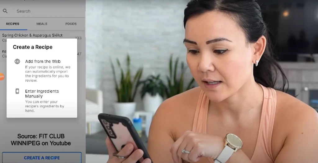 A woman holding her phone with the LoseIt app on the left hand of the screen showing how creating a recipe, entering ingredients in manually and adding recipes from the web are all easy options. 