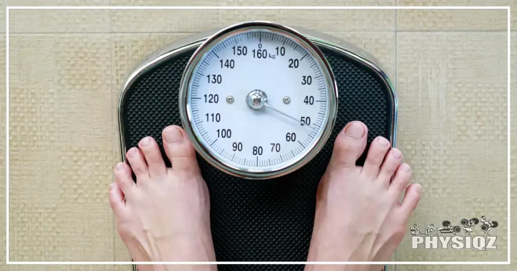 A Caucasian person's feet are on top of a dial bodyweight scale in a bathroom with textured tile, showing they weigh 50kg. 