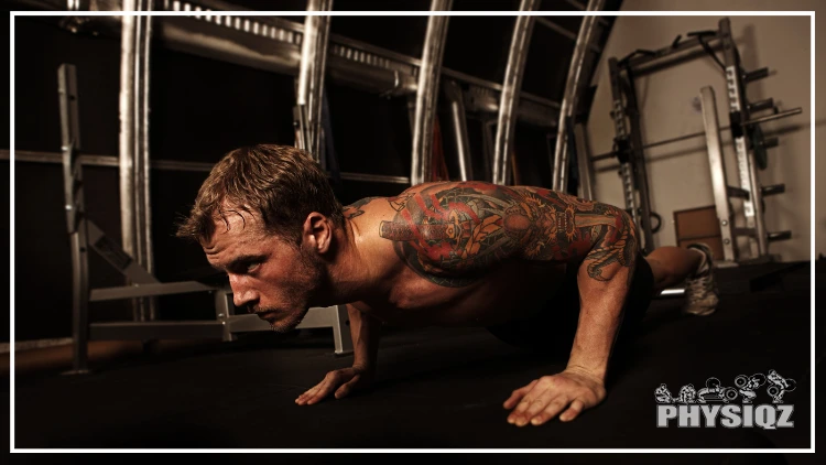 A man with a tattoo on his left arm sweats profusely while doing push-ups, wondering if performing them every day is overtraining.