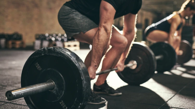 A guy preparing to deadlift with a mixed grip as he works through minimum effective volume through to maximum recovery volume while periodizing. 
