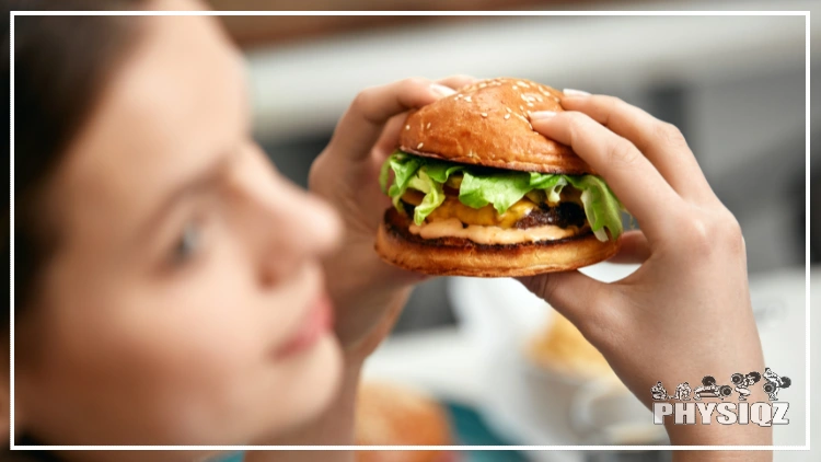 In the foreground, a woman's face is out of focus while the background is focused and shows her holding a Smash Burger keto cheeseburger with both hands, and the burger is topped with cheese, an egg, lettuce, and a yellow sauce.