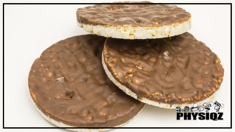 Three rice cakes are stacked on top of each other and each is lopsided and covered in a thin layer of chocolate. 