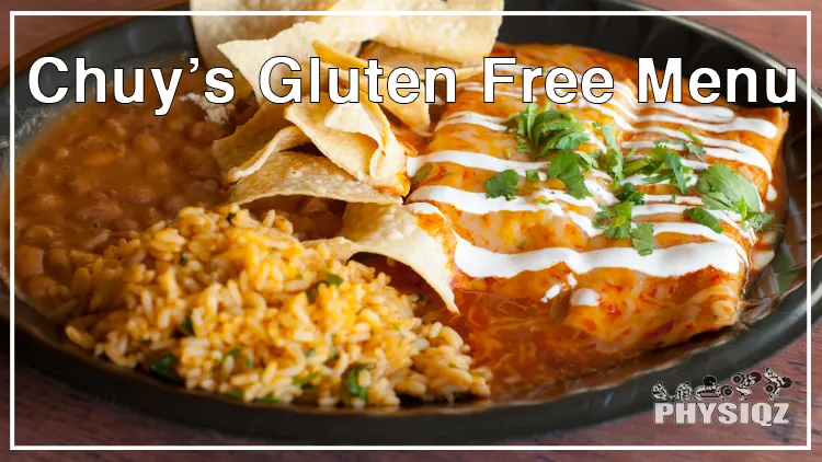 On a black bowl is a Mexican food from Chuy's gluten free menu, made with chicken meat, spices, cheese, and tortilla chips and placed on a wooden surface.