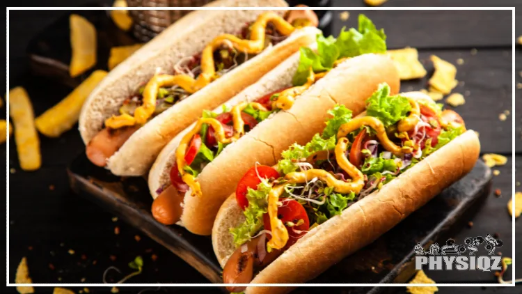 Three hot dogs with lettuce, tomatoes, and other low carb condiments on them such as mustard and ketchup. 