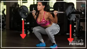 In a gym, a guy is getting into the bottom of a squat, or in the hole, with a red arrow showing the vertical squat bar path that goes from the barbell to the ground.