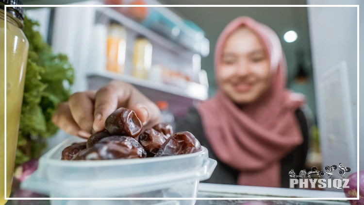 A girl with a pink hood and black shirt grabs a dates fruit in a white container.