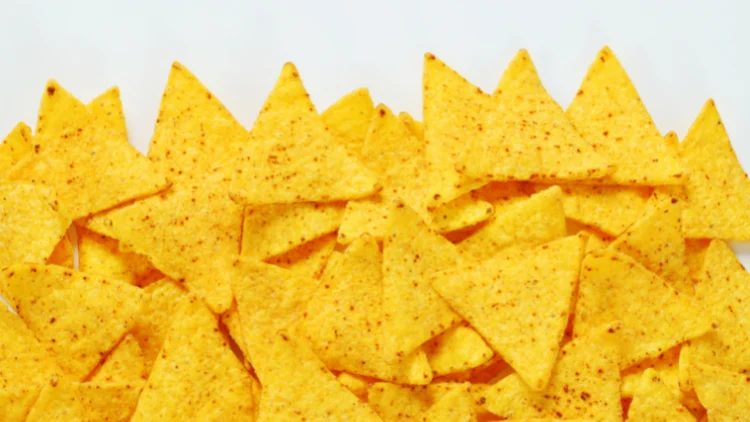 A bunch of triangle-shaped chips scattered all over a white surface.