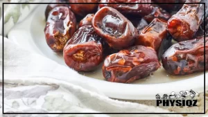 A white plate is filled with fresh dates that are red, brown and yellow in color while sitting on top of a white table cloth that a low carb dieter laid out before asking their significant other "Are dates keto friendly, or should we take them off the table?".