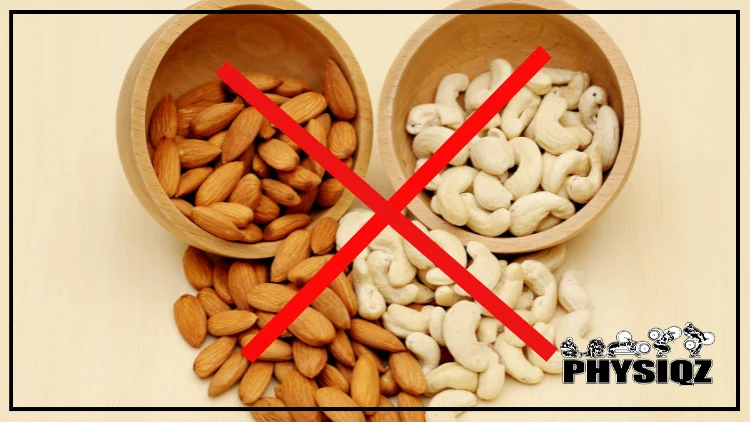 Two wooden bowls are laid on their side spilling out almonds in the bowl on the left and cashews in the bowl on the right with a large red X is intron of the bowls. 