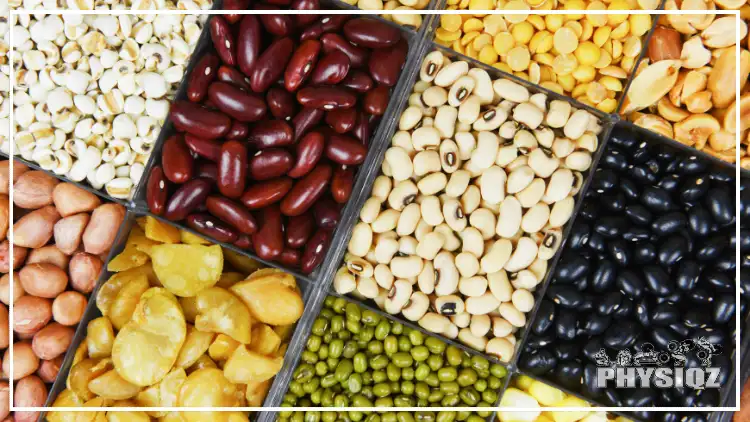 A table is filled with a variety of beans, including kidney beans, black beans, and black eyed peas. 