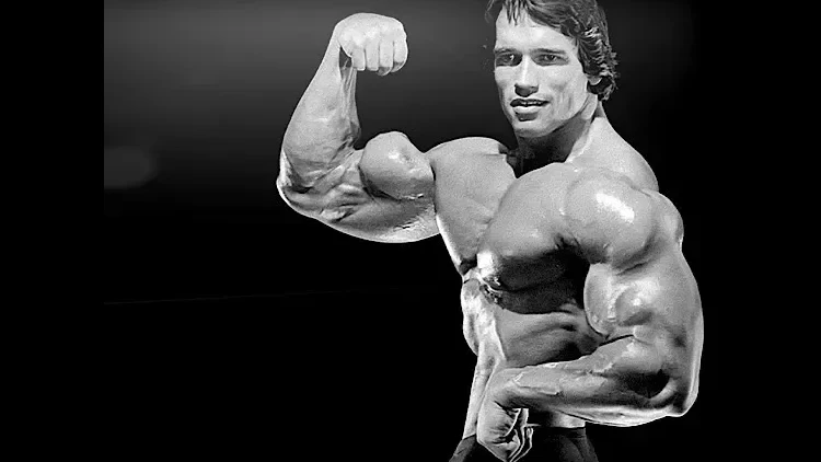 Arnold Schwarzenegger flexing his biceps with a high peak and a black background.