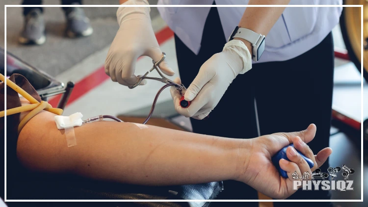 A person donating plasma has their arm out as a health care professional fixes the needle into their arm. 