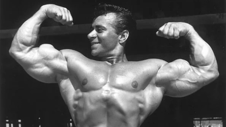 A black and white picture of Gene flexing his muscles.