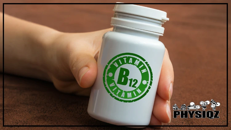 A white woman's hand with long nails holds a white pill bottle labeled "Vitamin B12" in green, set against a backdrop of brown suede material.