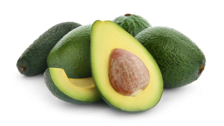 Five fresh, green avocados arranged together, with one of them sliced in half and placed in the foreground, showing its creamy, yellow-green flesh and brown seed.