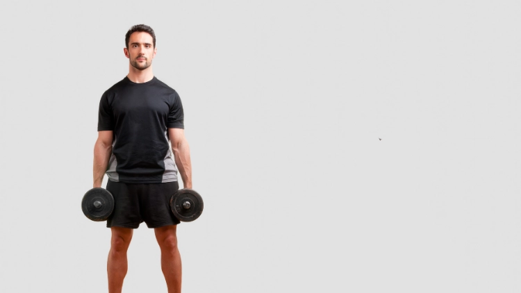 A man in black shirt and black short standing while holding dumbbell with both hands with a plain white background.