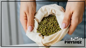 A woman with beige colored nails and wearing a denim pants, is wondering, are mung bean keto friendly, while grasping a white bag that contains a countless green mung beans.