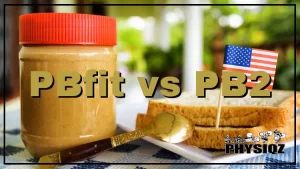 A jar of peanut butter with a red cap, beside it a white square plate with two slices of bread placed side by side, a small toothpick flag of the USA is stuck into the top of the bread, a golden spoon rests with its head placed in the plate next to the bread.