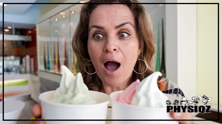 A woman holding two frozen yogurt cups in white paper, looking shocked as she looks the contents of the cups.